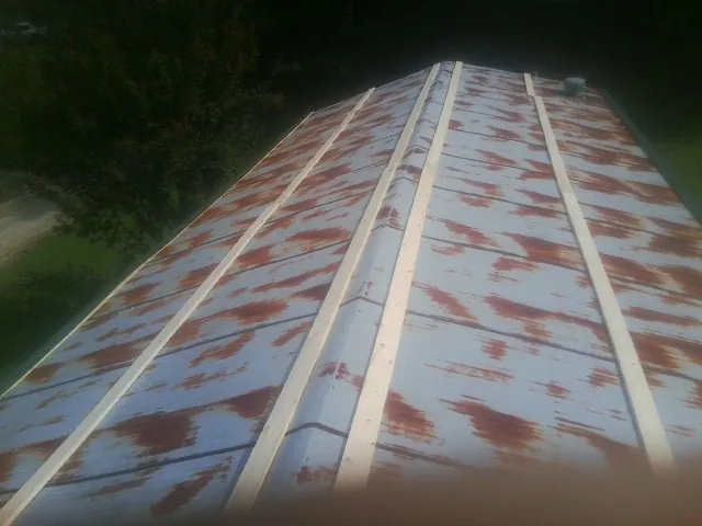 Rusted metal roof panels with new wood purlins before replacement — Storm Damage Roof Repair in Dripping Springs by Roofing Brothers