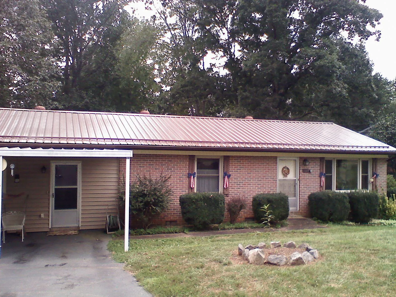 Bronze metal roof and carport on a brick ranch home in Dripping Springs