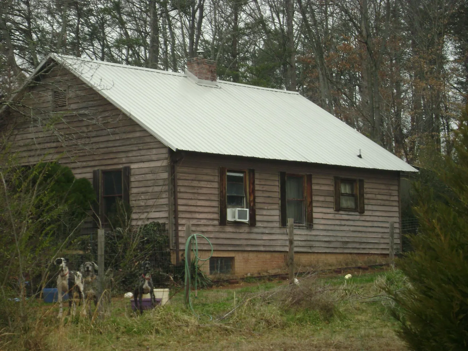 White metal roof on an old wood sided farmhouse, from a Metal Roof Installation job in Dripping Springs
